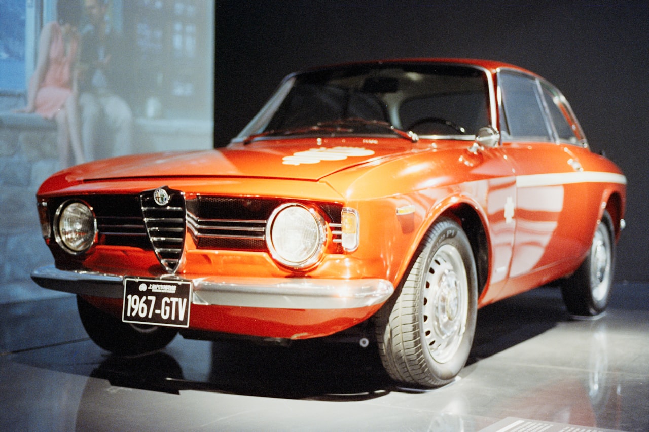 Red Alfa Romeo GTV sports car, front three-quarter view showing Pininfarina design