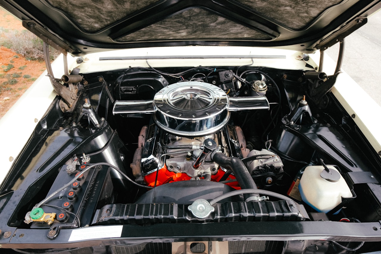 Classic car engine bay showing the V8 engine, radiator, and ancillary components